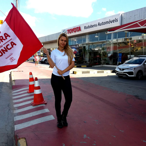 Promotora da Toyota Rodobens balançando bandeira